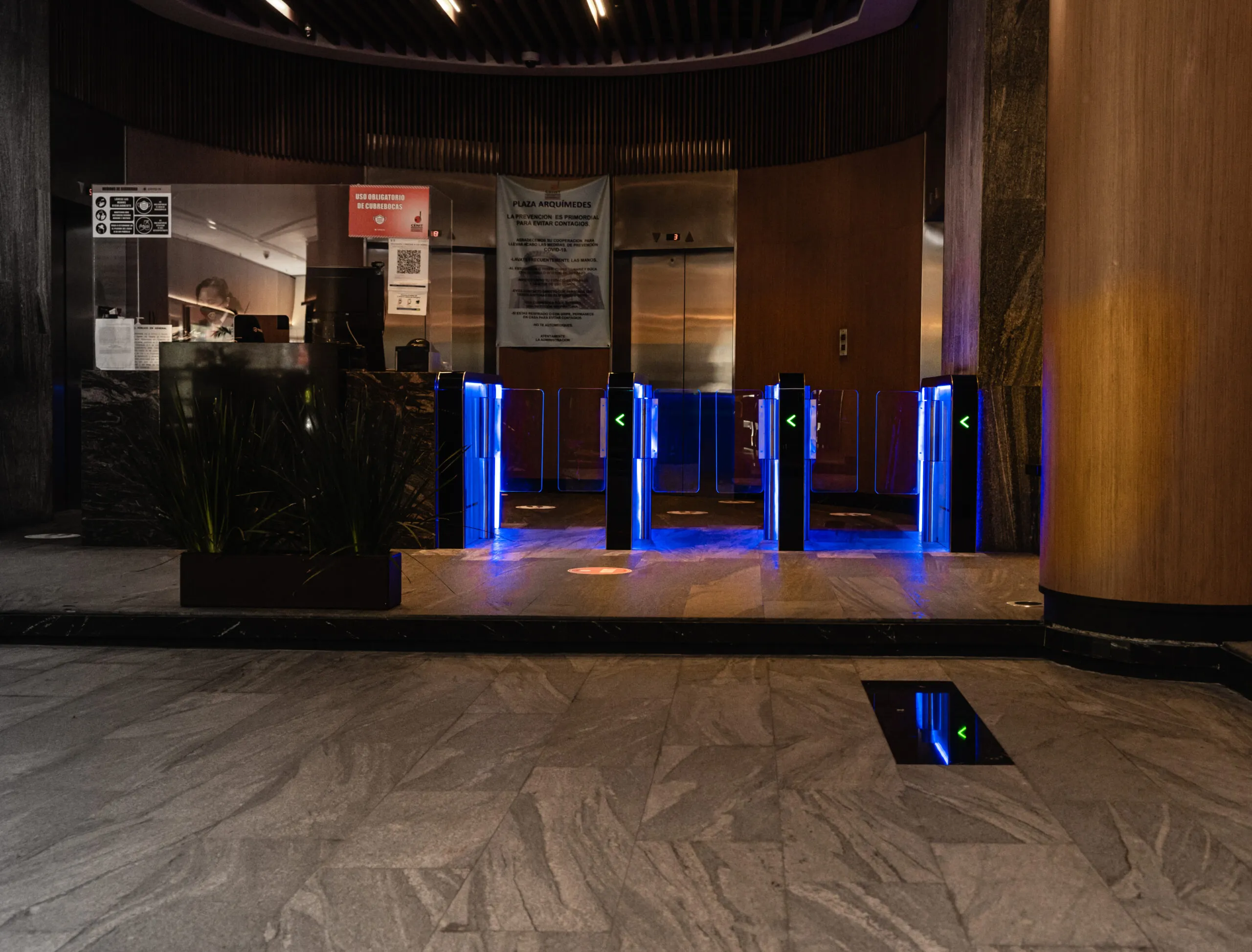 Lobby corporativo con carriles de acceso iluminados en azul