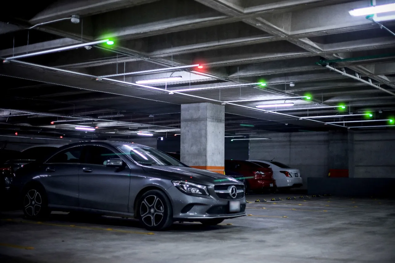 Estacionamiento subterráneo con indicadores verdes y rojos sobre cada cajón